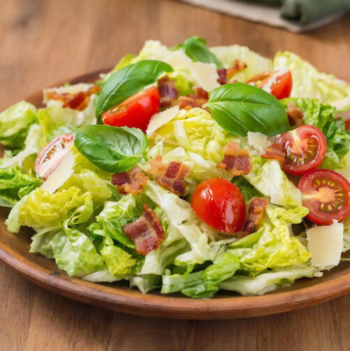 Вот рецепт вкусного салата Цезарь с жареным беконом, томатами черри и базиликом: